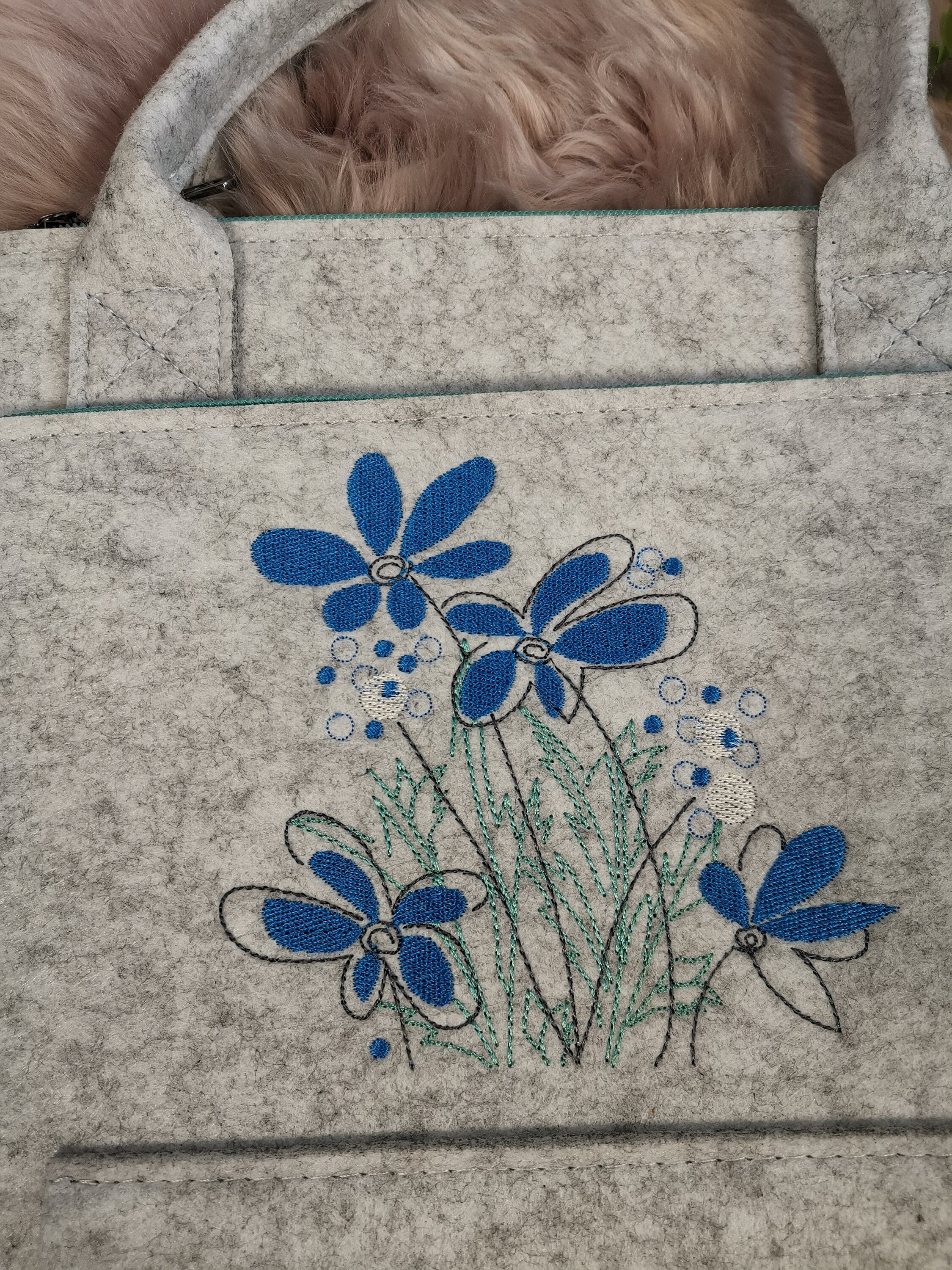 Laptoptasche aus Filz mit einer Blumenwiese bestickt